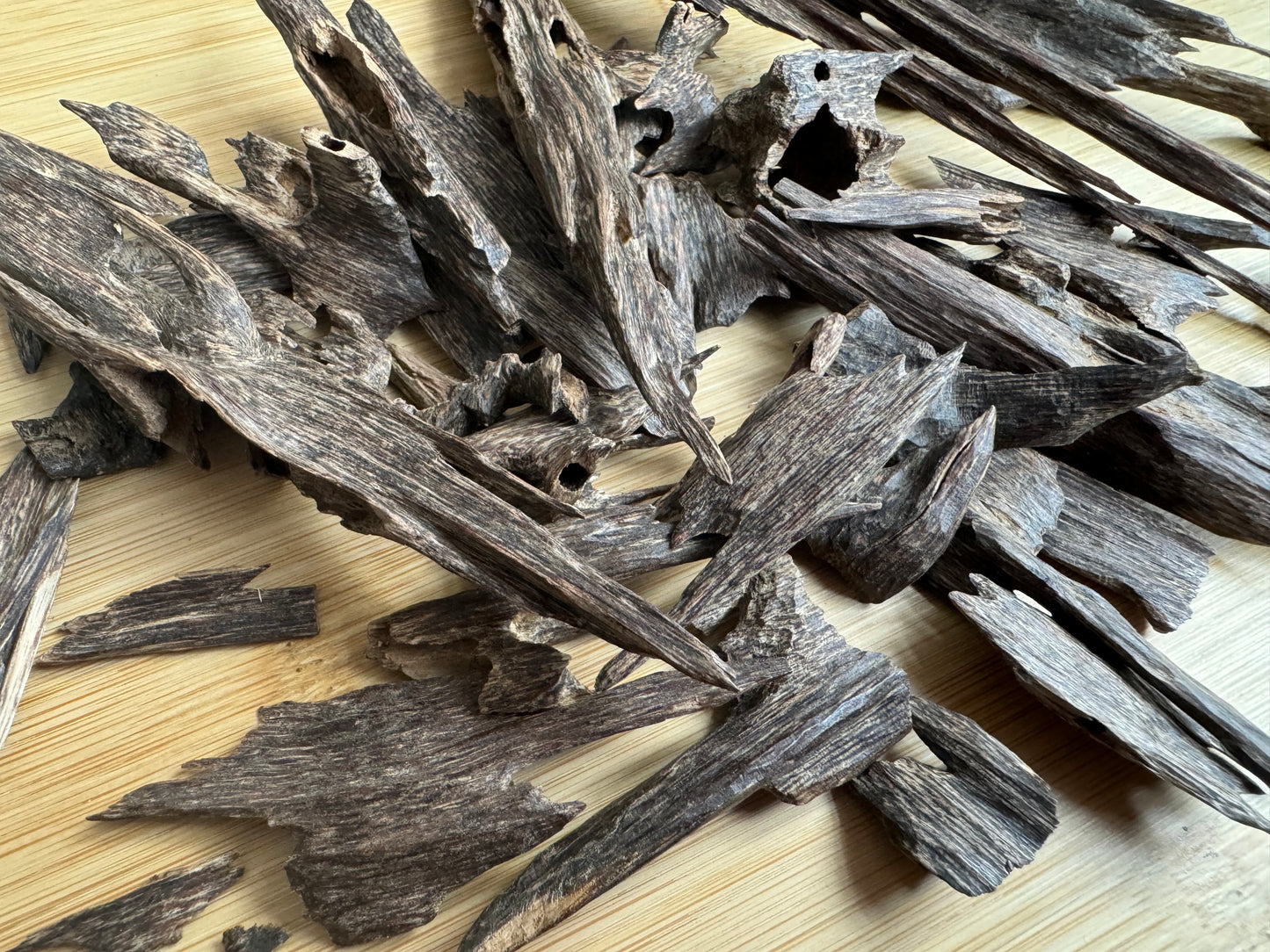 Wild Hindi Agarwood chips on a wooden table