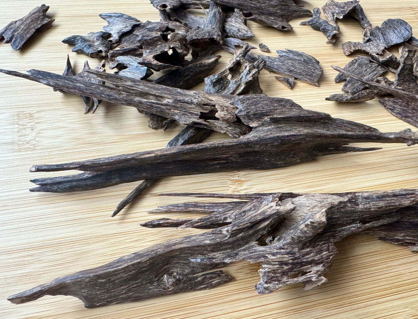 Wild Hindi Agarwood chips on a wooden table