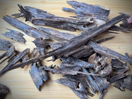 wild Hindi Agarwood chips on a wooden table