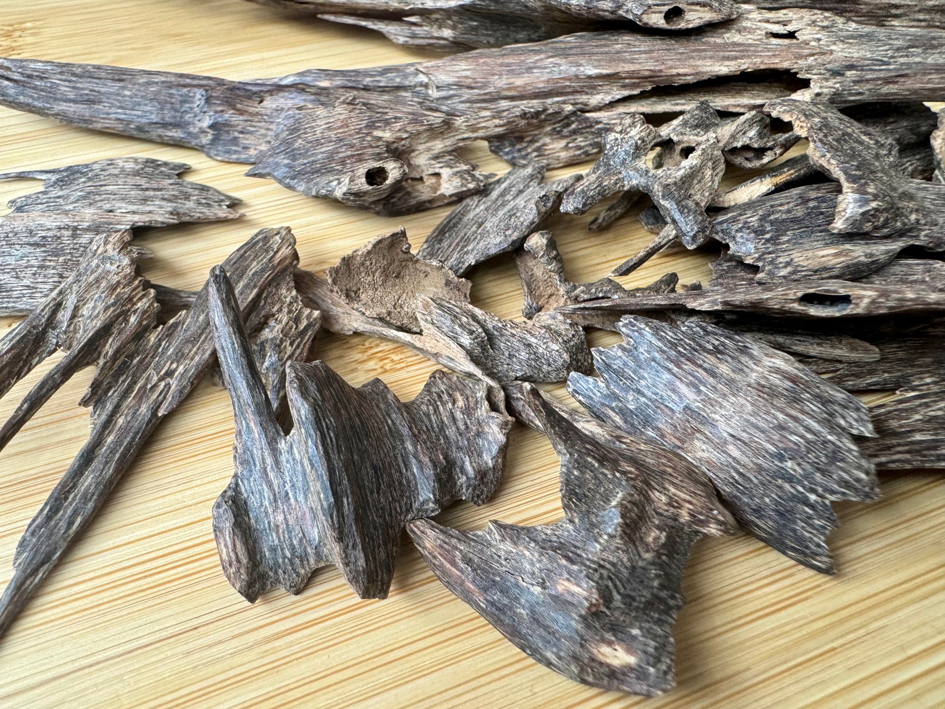 Wild Hindi Agarwood chips on a wooden table