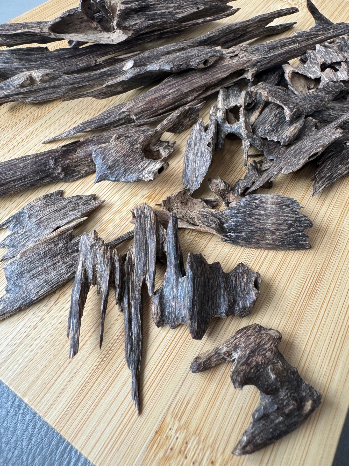 Wild Hindi Agarwood chips on a wooden table