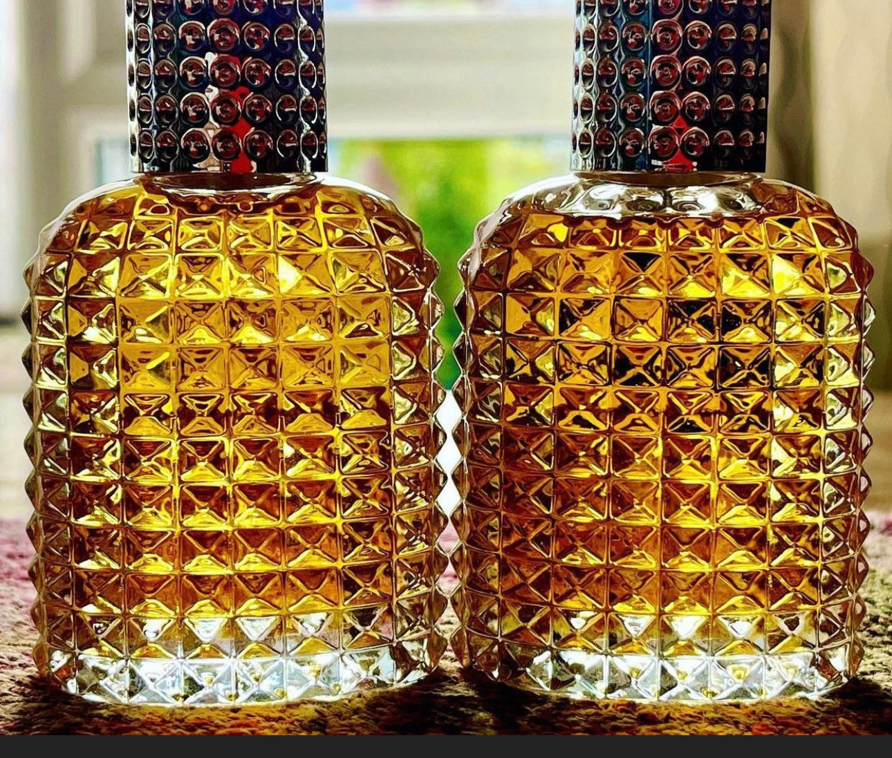 Two glass bottles of wild Sri Lankan sandalwood oil on a table