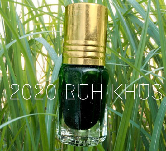 An Attar, bottle of Ruh Khus resting on wild vetiver grass
