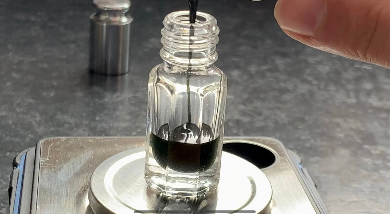 A man pouring vetiver essential oil into a bottle on the table