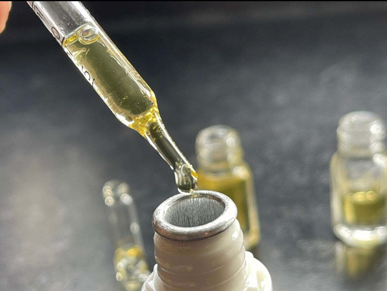 Man pouring Indian Sandalwood essential oil from a pipette into a bottle