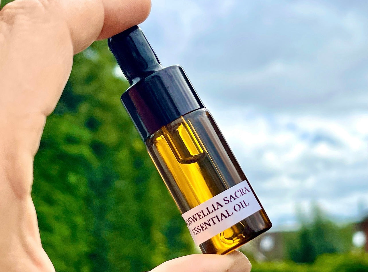 Man holding a bottle of Boswellia Sacra Frankincense essential oil