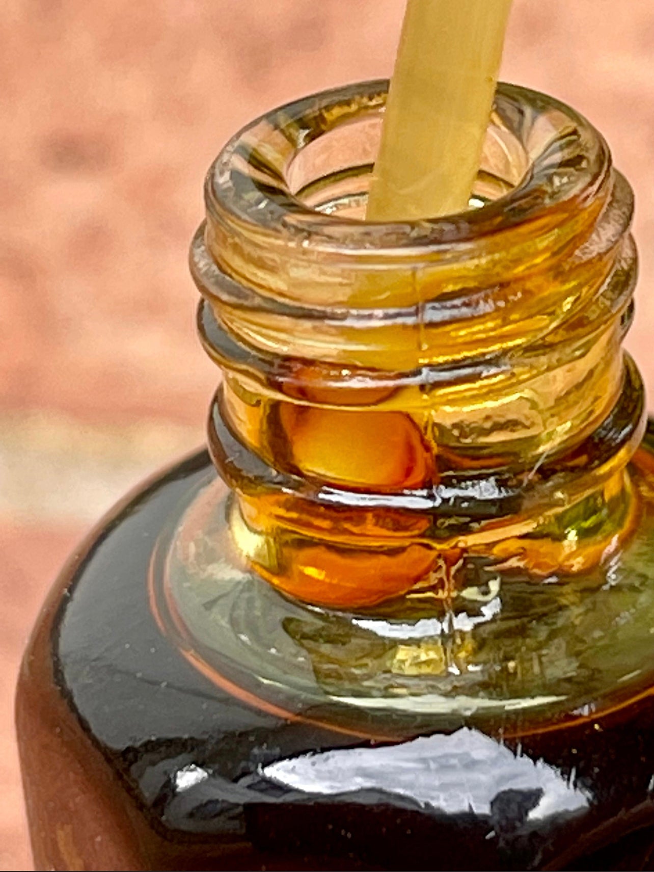 Close up of a Man holding a pipette in a bottle of Oud oil