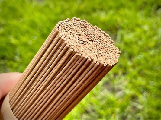 Man holding a handful of artisan agarwood incense sticks