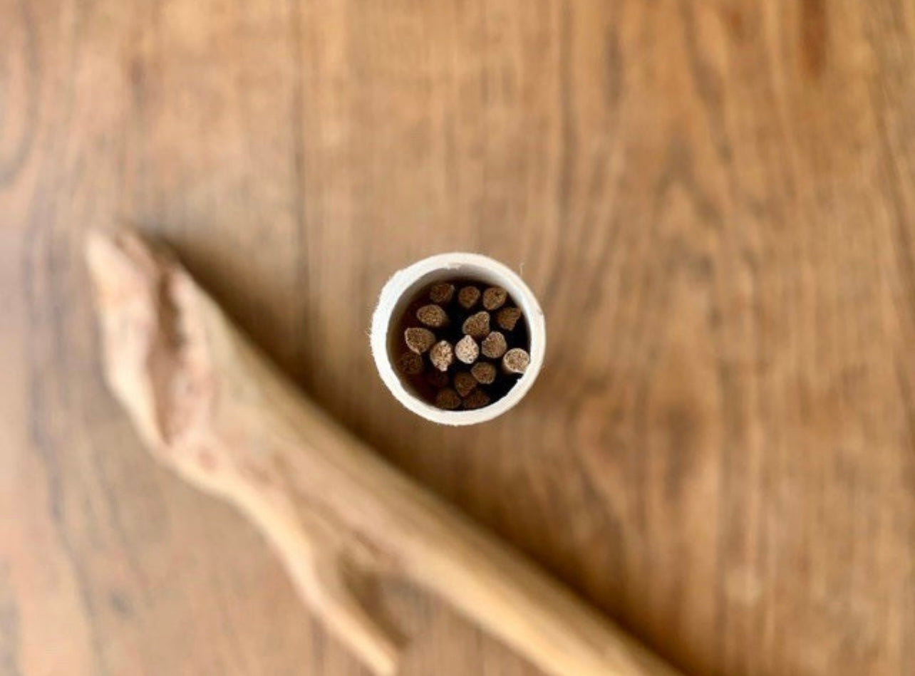 Tube of artisan hand made Timor sandalwood incense sticks on a table