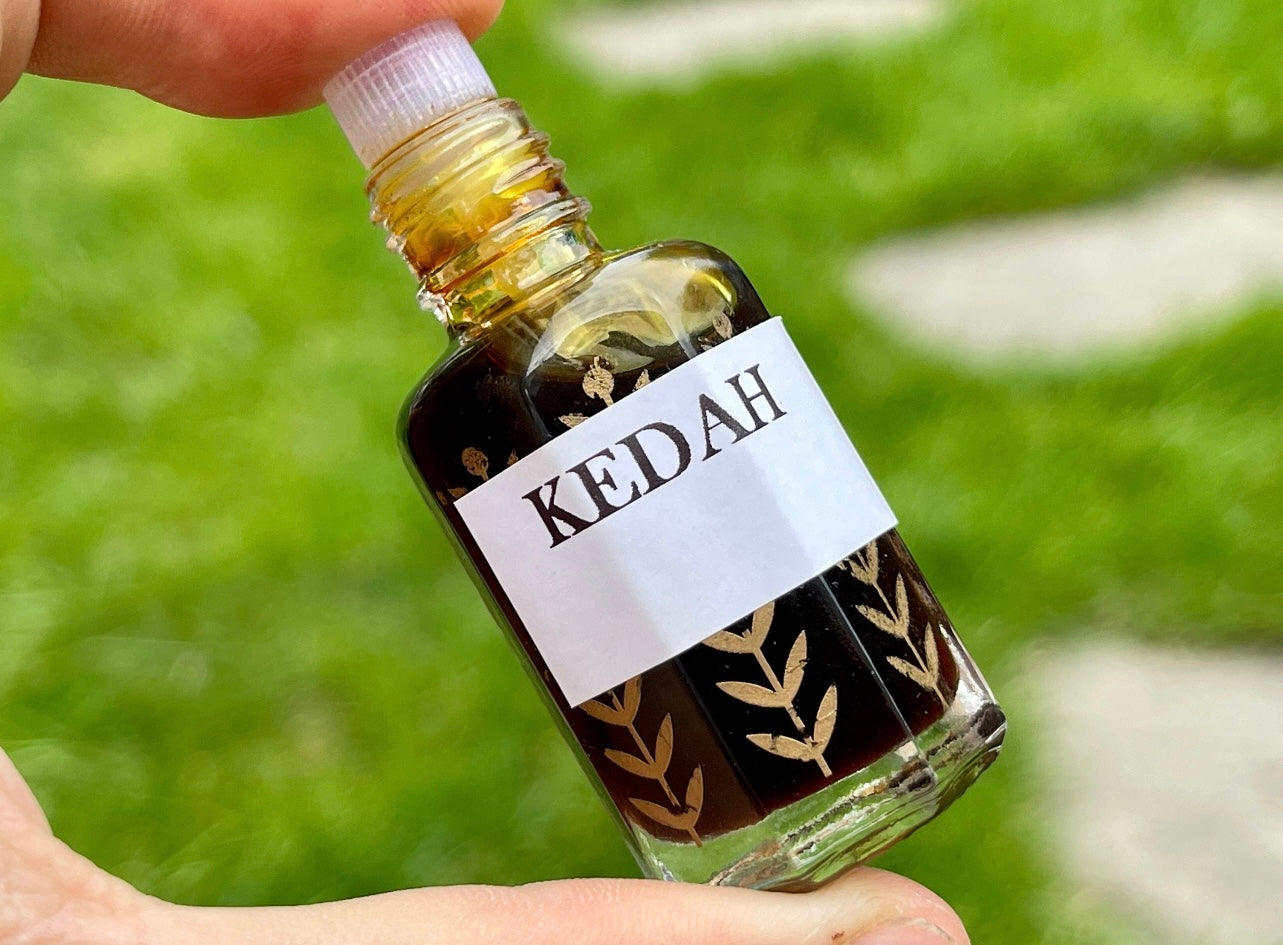 A man holding a bottle of Kedah Oud oil