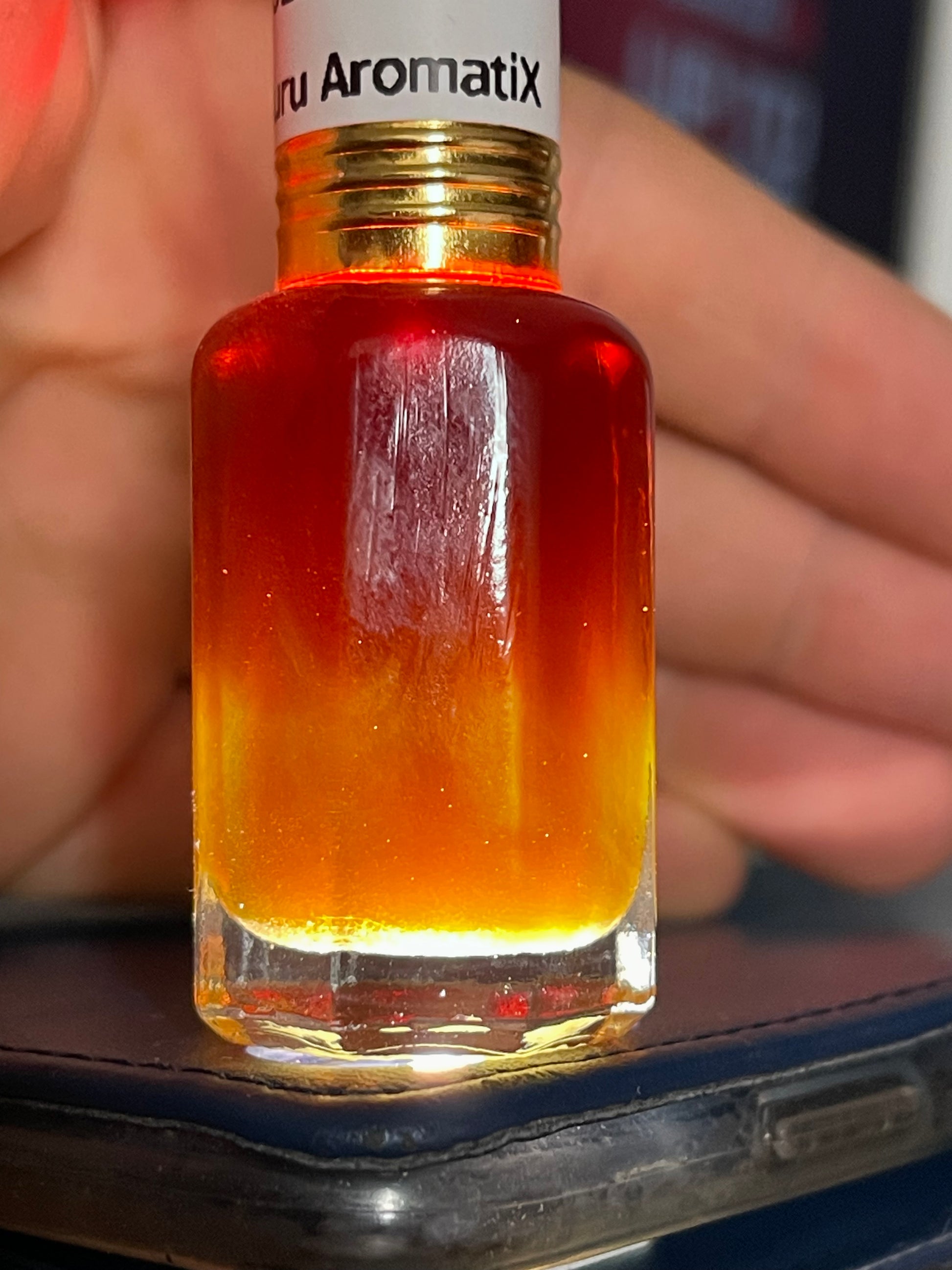 Man holding an attar bottle of wild Kalimantan Oud oil