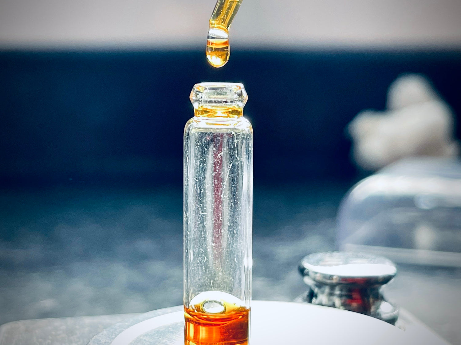 A man filling a vial with Oud oil using a pipette 